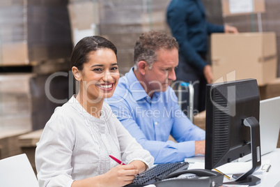 Two managers working on laptop at desk