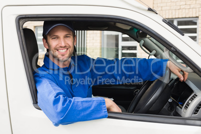 Delivery driver smiling at camera in his van