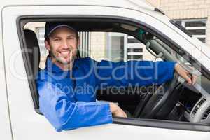 Delivery driver smiling at camera in his van