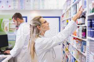 Pharmacist looking up at medicines