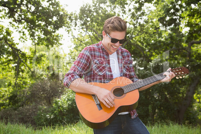 Handsome hipster playing the guitar