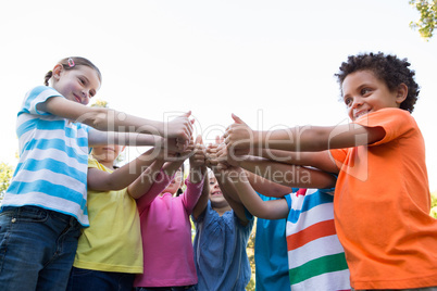 Little children putting thumbs up together