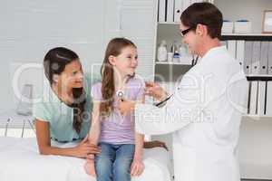 Doctor examining little girl with her mother