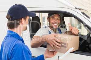 Delivery driver handing parcel to customer in his van