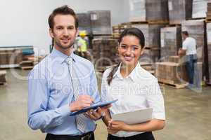 Smiling warehouse managers working together