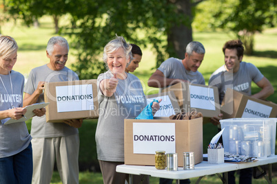 Happy family holding donations boxes with thumb up