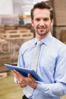 Manager using digital tablet in warehouse