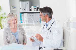 Doctor writing prescriptions for senior female patient