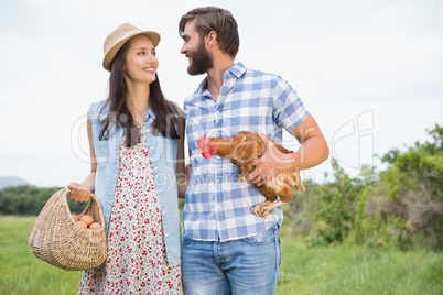 Happy farmers holding chicken and eggs