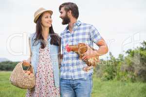 Happy farmers holding chicken and eggs