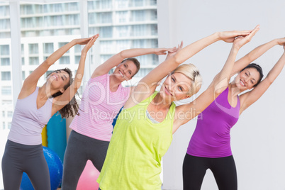 Women practicing stretching exercise at fitness studio