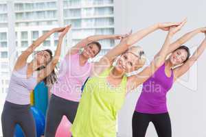 Women practicing stretching exercise at fitness studio