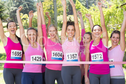 Smiling women running for breast cancer awareness