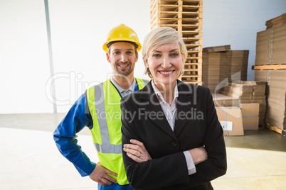 Portrait of smiling warehouse worker and his manager