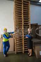 Worker and his manager in front of a stack of pallet