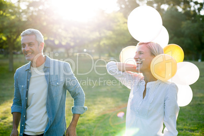 Happy couple with balloons at the park