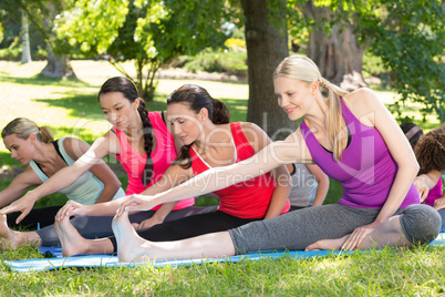 Fitness group doing yoga in park