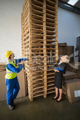 Warehouse worker and his manager looking stack of pallet