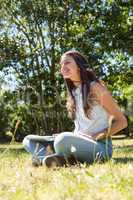 Pretty brunette using laptop in park