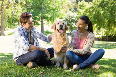 Happy couple with their dog in the park