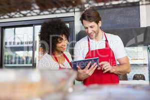 Colleagues in red apron using tablet