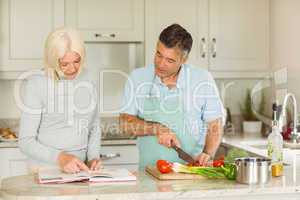 Happy mature couple following a vegetarian recipe
