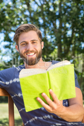 Young man reading on park bench