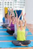 Women practicing yoga in fitness class