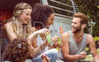 Hipsters blowing bubbles in camper van