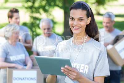 Smiling volunteer brunette using tablet pc