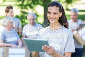 Smiling volunteer brunette using tablet pc