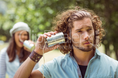 Young couple shouting through tin cans