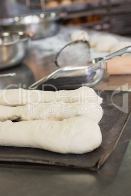 Worktop with uncooked baguettes and breads