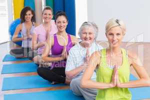 Women meditating with hands joined during fitness class