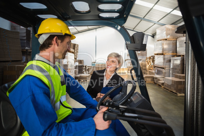 Warehouse manager talking with forklift driver