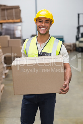 Worker carrying box in warehouse