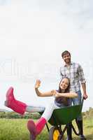 Man pushing his girlfriend in a wheelbarrow