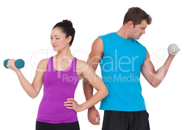 Fit man and woman lifting dumbbells