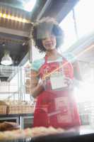 Employee in red apron holding box