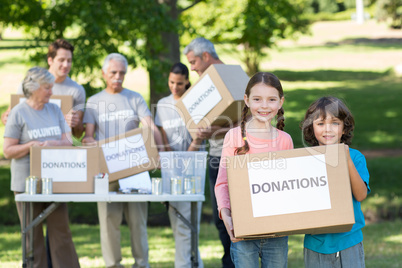 Happy siblings holding donation box