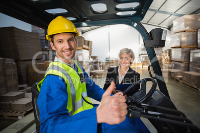 Warehouse worker and his manager smiling at camera