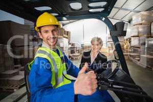 Warehouse worker and his manager smiling at camera