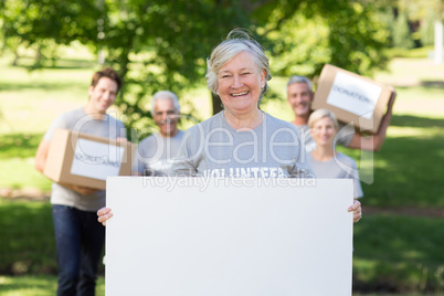 Happy volunteer grandmother holding blank