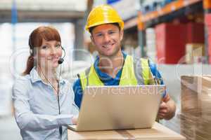 Smiling businesswoman wearing headset using laptop