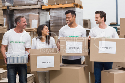 Happy team of volunteers holding donations boxes