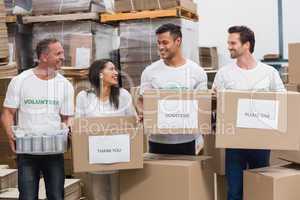 Happy team of volunteers holding donations boxes