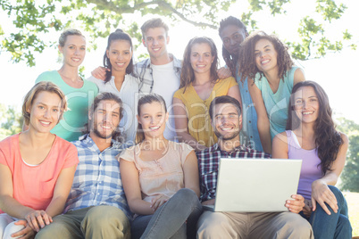 Friends looking at laptop in the park