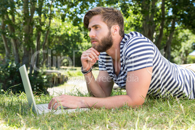 Hipster using laptop in the park