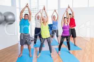 People doing stretching exercise in yoga class