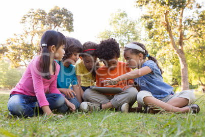 Little children using tablet in park